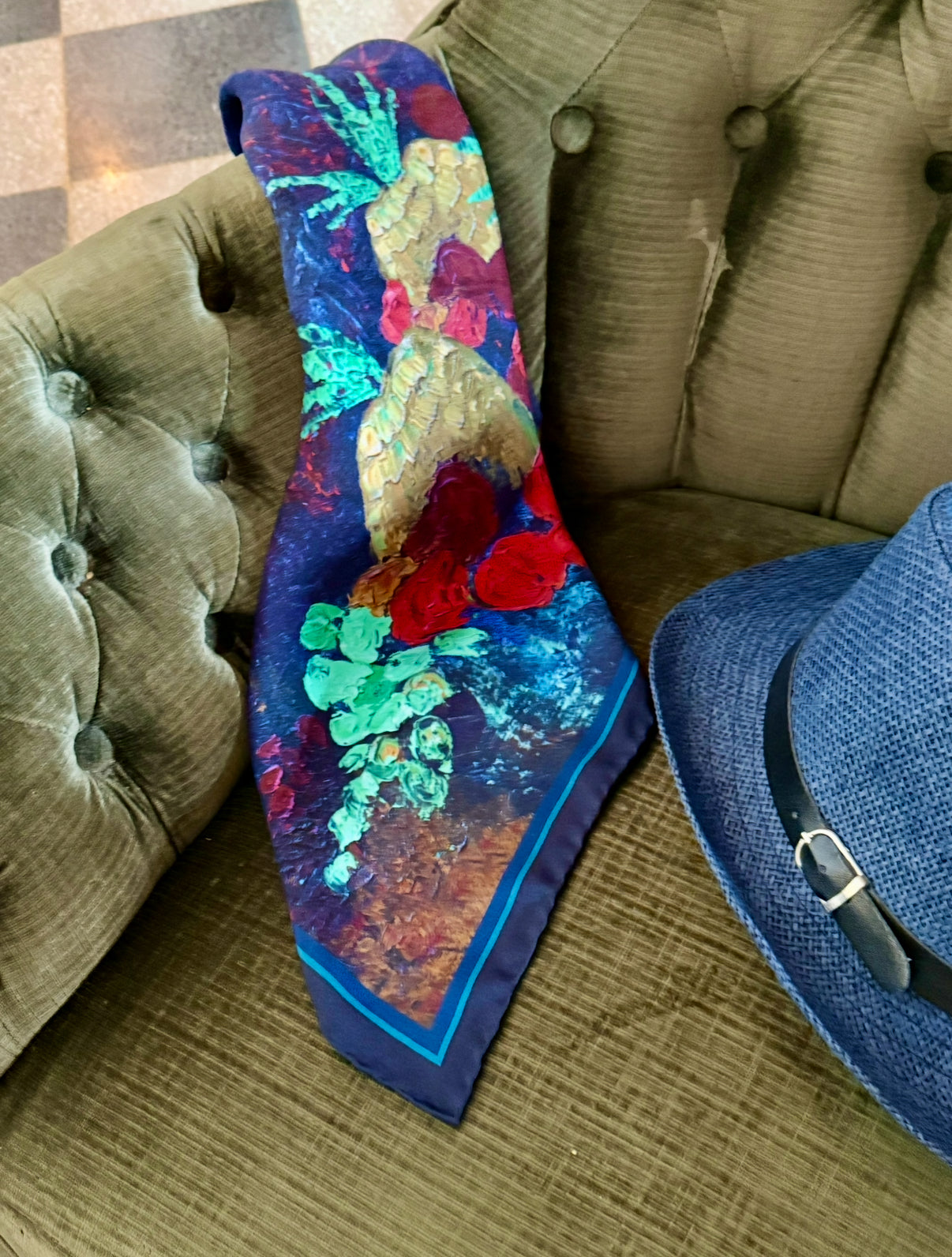 Karnik by TK-LA silk twill neckerchief scarf. Karnik by TK-LA scarf is vivid with bold colors of blue, cherry red, seafoam green, mustard yellow. The silk twill scarf has pineapples, apples, grapes and it is an oil paining transformed into silk fabric in Como, Italy. The silk scarf is 100% silk twill, hand sewn and part of sale is donated to Alzheimer's research and support. 