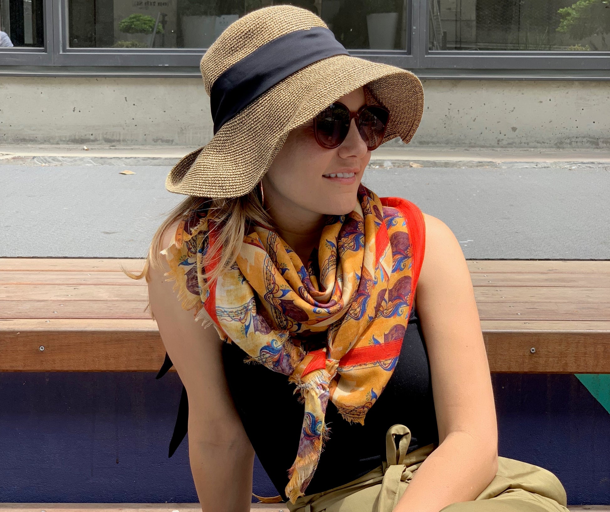 a girl wearing Karnik by TK-LA scarf out enjoying the sun. The orange scarf gives her outfit a glow 