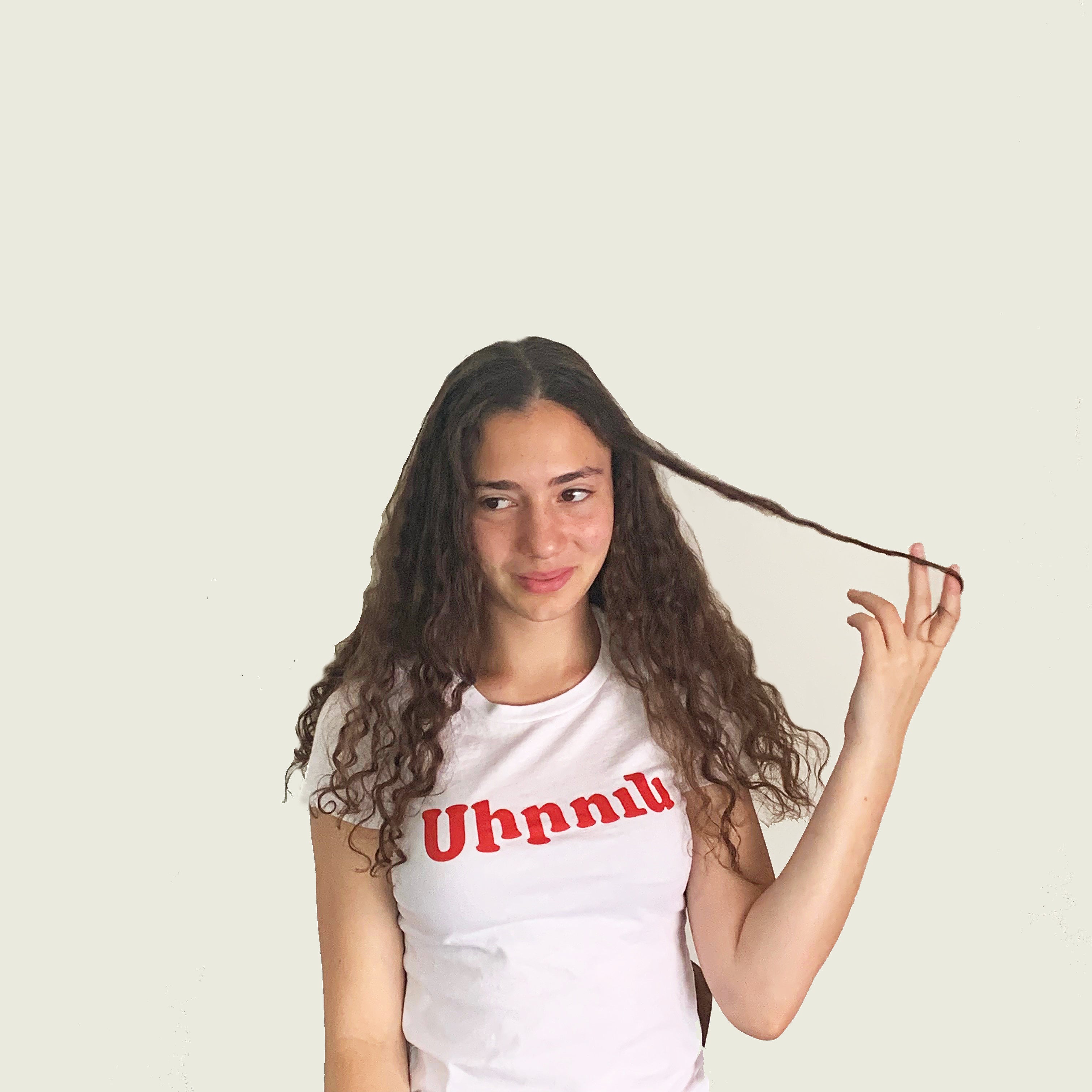 pretty girl wearing a white siren tee playing with her long curly hair